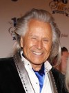 Following an FBI raid on his Manhattan headquarters over sex assault allegations, fashion mogul Peter Nygard says he is stepping down as chairman of his company. Peter Nygard, left, and Courtney Stodden arrive at the 24th Night of 100 Stars Oscars Viewing Gala at The Beverly Hills Hotel in Beverly Hills, Calif., on March 2, 2014. THE CANADIAN PRESS/AP, Invision - Annie I. Bang