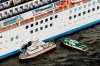 Japan Coast Guard's patrol boat, left, is brought alongside the cruise ship Diamond Princess to take passengers tested positive for coronavirus to hospitals off Yokohama, south of Tokyo, Wednesday, Feb. 5, 2020. Japan said Wednesday 10 people on the cruise ship have tested positive for the new virus and were being taken to hospitals. Health Minister Nobukatsu Kato said all the 3,700 people and passengers on the ship will be quarantined on board for up to 14 days under Japanese law. (Hiroko Harima/Kyodo News via AP)