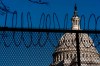 The Dome of the Capitol Building is visible through razor wire installed on top of fencing on Capitol Hill in Washington, Thursday, Jan. 14, 2021. (AP Photo/Andrew Harnik)