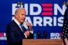 Democratic presidential candidate former Vice President Joe Biden removes his face mask as he arrives to speak, Friday, Nov. 6, 2020, in Wilmington, Del. (AP Photo/Carolyn Kaster)