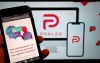 The website of the social media platform Parler is displayed in Berlin, Jan. 10, 2021. The platform's logo is on a screen in the background. The conservative-friendly social network Parler was booted off the internet Monday, Jan. 11, over ties to last week's siege on the U.S. Capitol, but not before hackers made off with an archive of its posts, including any that might have helped organize or document the riot. (Christophe Gateau/dpa via AP)