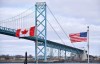 Canadian and American flags fly near the Ambassador Bridge at the Canada-USA border crossing in Windsor, Ont. on Saturday, March 21, 2020. THE CANADIAN PRESS/Rob Gurdebeke