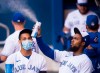 Toronto Blue Jays left fielder Lourdes Gurriel Jr., left, watches teammate Teoscar Hernandez, right, spray sanitizer in the dugout during first inning MLB intersquad baseball action in Toronto on Friday, July 17, 2020. The Blue Jays can't play home games in Toronto this season after the federal government rejected the club's plan to use Rogers Centre on Saturday. THE CANADIAN PRESS/Nathan Denette