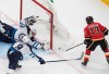 Winnipeg Jets goalie Connor Hellebuyck (37) is scored on by Calgary Flames' Johnny Gaudreau (13) as Jets' Andrew Copp defends during second period NHL qualifying round game action in Edmonton, on Saturday August 1, 2020. THE CANADIAN PRESS/Jason Franson