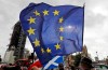 A EU supporter waves a flag in front of parliament in London, Wednesday, Sept. 30, 2020. The ninth round of trade talks between the EU and Britain have started in Brussels as the two sides continue to clash over the controversial UK Internal Market Bill. (AP Photo/Frank Augstein)