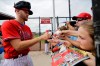 Philadelphia Phillies Zack Wheeler, left, signs autographs during a spring training baseball workout Friday, Feb. 14, 2020, in Clearwater, Fla. (AP Photo/Frank Franklin II)