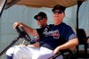 Atlanta Braves manager Brian Snitker, right, and bench coach Walt Weiss watch from a golf cart as the pitchers and catchers get loose during spring training baseball camp Thursday, Feb. 13, 2020, in North Port, Fla. (AP Photo/John Bazemore)