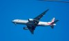 An American Airlines Boeing 777 is framed by utility wires as it prepares to land at Miami International Airport, Wednesday, Jan. 27, 2021, in Miami. The airline said Thursday that it lost $2.2 billion in the fourth quarter, with revenue plunging by nearly two-thirds from a year earlier. And the airline lost $8.9 billion for the full year after earning nearly $1.7 billion in 2019. .(AP Photo/Wilfredo Lee)