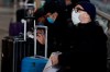 People wearing sanitary masks sit as they wait at the Centrale main railway station in Milan, Italy, Monday, Feb. 24, 2020. Italy has been scrambling to check the spread of Europe's first major outbreak of the new viral disease amid rapidly rising numbers of infections and a third death, calling off the popular Venice Carnival, scrapping major league soccer matches in the stricken area and shuttering theaters, including Milan's legendary La Scala. (AP Photo/Luca Bruno)