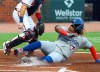 Toronto Blue Jays Vladimir Guerrero Jr. scores past Atlanta Braves catcher Travis D'Arnaud on a sacrifice fly by Danny Jansen during the second inning in a baseball game on Wednesday, Aug. 5, 2020, in Atlanta. (Curtis Compton/Atlanta Journal-Constitution via AP)