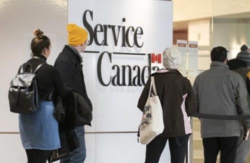 People line up at a Service Canada office in Montreal on Thursday, March 19, 2020. THE CANADIAN PRESS/Paul Chiasson