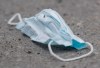 A discarded face mask is shown on a street next to a mobile COVID-19 testing clinic in Montreal, Sunday, May 17, 2020, as the COVID-19 pandemic continues in Canada and around the world. THE CANADIAN PRESS/Graham Hughes