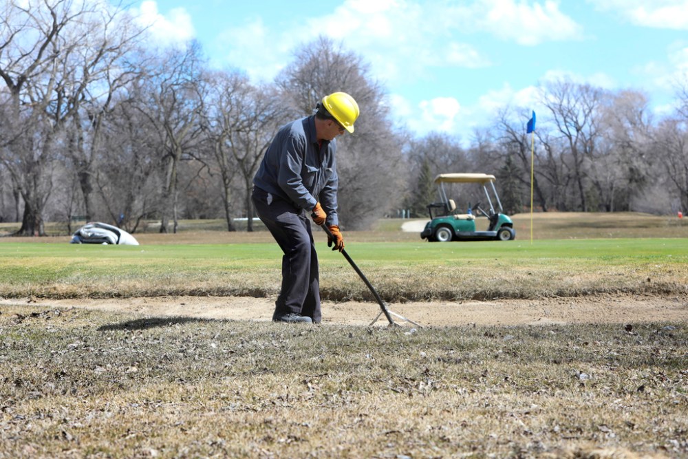 RUTH BONNEVILLE / WINNIPEG FREE PRESS FILES
Maintenance workers rake the sand traps at Kildonan Park Golf Course, one of several city-owned courses slated to open Monday.