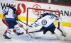 CP
Connor Hellebuyck and Neal Pionk keep Calgary's Rasmus Andersson from putting the puck in the net during the second period. (Jeff McIntosh / The Canadian Press)