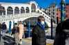 A man wearing a protective mask walks past the Rialto Bridge in Venice, Italy on Friday. The number of countries in which COVID-19 has been confirmed approached 60 by the end of the week. (Claudio Furlan / Lapresse)