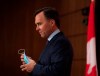 Minister of Finance Bill Morneau removes his mask as he prepares to announce his resignation during a news conference on Parliament Hill in Ottawa, on Monday, Aug. 17, 2020. THE CANADIAN PRESS/Justin Tang