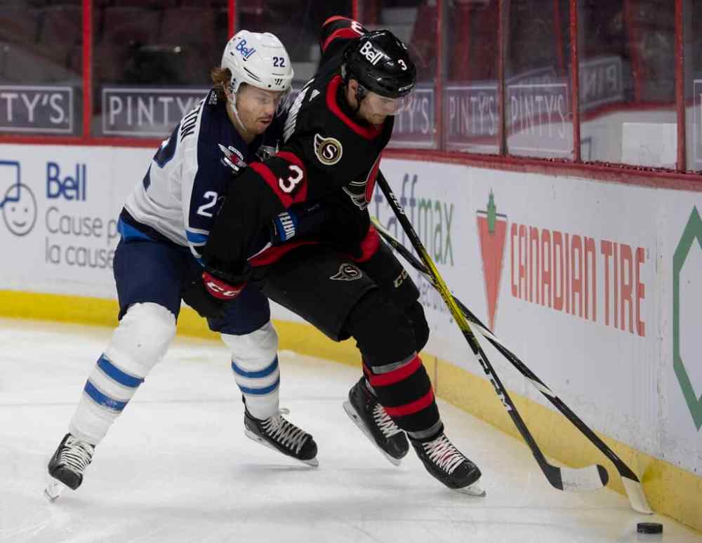 Winnipeg Jets centre Mason Appleton battles with Ottawa Senators defenceman Josh Brown along the boards during the first period Thursday in Ottawa. THE CANADIAN PRESS/Adrian Wyld
