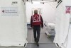 A Canadian Red Cross volunteer walks into a tent at a mobile hospital at the Jacques Lemaire arena in the Montreal suburb of LaSalle, Sunday, April 26, 2020. THE CANADIAN PRESS/Graham Hughes