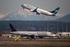 An Air Canada flight departing for Toronto, bottom, taxis to a runway as a Westjet flight bound for Palm Springs takes off at Vancouver International Airport, in Richmond, B.C., on Friday, March 20, 2020. British Columbia Health Minister Adrian Dix says he wants to see the evidence that it's safe for the country's two largest airlines to drop their in-flight distancing policies during the pandemic. THE CANADIAN PRESS/Darryl Dyck