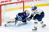 St. Louis Blues' David Perron (57) scores the game winning goal in overtime against Winnipeg Jets goaltender Connor Hellebuyck (37) in NHL action in Winnipeg on Friday, December 27, 2019. THE CANADIAN PRESS/John Woods