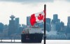 Downtown Vancouver is pictured in the background as a Canadian flag blows in the wind at the Lonsdale Quay in North Vancouver, B.C. Tuesday, March 24, 2020. THE CANADIAN PRESS/Jonathan Hayward