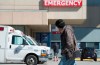 A man wears a protective face mask as he walks past the emergency department of the Royal Columbian Hospital in New Westminster, B.C. Friday, April 3, 2020. THE CANADIAN PRESS/Jonathan Hayward