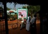 Villagers arrive for breakfast at an eatery next to a billboard featuring U.S. democratic vice presidential candidate Sen. Kamala Harris in Thulasendrapuram village, south of Chennai, Tamil Nadu state, India, Tuesday, Nov. 3, 2020. For many Indians, the American election is personal. The prospect that vice presidential candidate Kamala Harris — who has Indian origins — could occupy the second-highest political office in the U.S. has caught the imagination of millions of ordinary people in the world's largest democracy. (AP Photo/Aijaz Rahi)