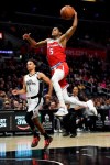 Sacramento Kings guard De'Aaron Fox, right, goes up for a dunk on a breakaway, next to Los Angeles Clippers guard Jerome Robinson during the second half of an NBA basketball game Thursday, Jan. 30, 2020, in Los Angeles. The Kings won 124-103. (AP Photo/Kelvin Kuo)