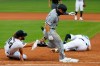 Detroit Tigers pitcher Daniel Norris, left, dives to tag out Chicago White Sox's Danny Mendick, center, as first baseman C.J. Cron (26) lies injured on the field in the fourth inning of a baseball game in Detroit, Monday, Aug. 10, 2020. (AP Photo/Paul Sancya)
