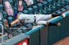 Milwaukee Brewers third baseman Eric Sogard gives over the fence and into the net to catch a foul ball off the bat of Minnesota Twins' Ehire Adrianza in the fourth inning of a baseball game Thursday, Aug. 20, 2020, in Minneapolis. (AP Photo/Jim Mone)