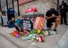 People gather and pray around a makeshift memorial, Tuesday, May 26, 2020, in Minneapolis, near the site where a black man, who was taken into police custody the day before, later died. The FBI and Minnesota agents are investigating the death of a black man in Minneapolis police custody after video from a bystander showed a white officer kneeling on his neck during his arrest as he pleaded that he couldn't breathe. (Elizabeth Flores/Star Tribune via AP)