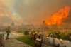 Emily Alvarenga / The Santa Clarita Valley Signal / The Associated Press files
In this April 28 file photo, a firefighter prepares to battle a wildfire from a backyard in Santa Clarita, Calif.