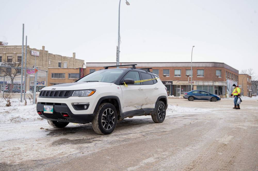 A car sits at the corner of Furby Street and Portage Avenue on Tuesday after being involved in a traffic accident because of the ruts along Portage. (Mike Sudoma / Winnipeg Free Press)