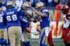 Andrew Harris (centre) celebrates his touchdown during his first game of the season on Sunday. (John Woods / The Canadian Press)