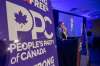 People's Party of Canada Leader Maxime Bernier and wife Catherine Letarte speaks from a podium to supporters during the PPC headquarters election night event in Saskatoon, Sask., Monday, Sept. 20, 2021. THE CANADIAN PRESS/Liam Richards