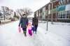 MIKAELA MACKENZIE / WINNIPEG FREE PRESS
Emely Camia (from left), Queenlloy, 4, and Kingcarlos, 12, walk by Strathcona School in Winnipeg Tuesday. Winnipeg School Division is doing away with full-day kindergarten after the 2021-22 academic year.