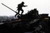 VADIM GHIRDA / ASSOCIATED PRESS
A Ukrainian serviceman walks on a destroyed Russian fighting vehicle in Bucha, Ukraine. To date, Canada has stepped up as a contributor of “lethal” military aid and support to Ukrainian troops.