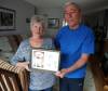 Ken and Mary Butchart with a photo of their deceased bichon frise, Holly, who was badly mauled in 2018 by a dog they believe was a pitbull. (Jason Halstead / Winnipeg Free Press)