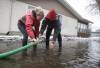 Cameryn Johnson and Brett Hanslit check their pumps around their home after a railway ditch overflowed its banks and flooded their property on Rizzuto Bay Sunday. (John Woods / Winnipeg Free Press)