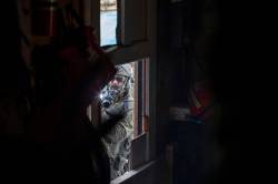 Amber Bracken photo
Militarized police breach a locked house at Coyote Camp with axes and chainsaws on Nov. 19.