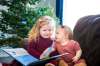 MIKAELA MACKENZIE / WINNIPEG FREE PRESS
Three-year-old Holly Parker (left) and her 10-month-old sister Penny share a Christmas book by the tree in their living room.