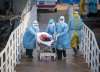 Xiao Yijiu/Xinhua via AP
Medical workers in protective suits help transfer the first group of patients into the newly-completed Huoshenshan temporary field hospital in Wuhan in central China’s Hubei province. China said Tuesday the number of infections from the new virus surpassed 20,000.