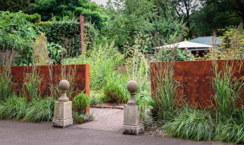 Carex Tours photo
A weathering steel wall frames the entrance to German designer Peter Janke’s herb garden.