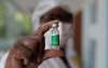 A health worker shows a vial of the Oxford-AstraZeneca vaccine for COVID-19 being used during a priority vaccination program for the elderly at a vaccination center in Rio de Janeiro, Brazil, Monday, Feb. 1, 2021. (AP Photo/Silvia Izquierdo)
