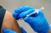 FILE - In this Jan. 5, 2021, file photo, a healthcare worker receives a second Pfizer-BioNTech COVID-19 vaccine shot in Southfield, Mich. On Friday, Jan. 8, 2021, The Associated Press reported on stories circulating online incorrectly asserting that COVID-19 vaccines that rely on messenger RNA technology will teach the body to attack itself, leading to autoimmune disease. The mRNA vaccines for COVID-19 contain a genetic code that trains the immune system to recognize the spike protein on the surface of the virus to generate an immune response and fight it. A lack of understanding around how mRNA vaccines work has led to a flurry of misinformation around the vaccines. (AP Photo/Paul Sancya, File)