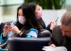 People wear masks as a precaution due to the coronavirus outbreak as they wait for the arrivals at the International terminal at Toronto Pearson International Airport in Toronto on Saturday, January 25, 2020.THE CANADIAN PRESS/Nathan Denette