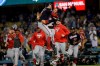 FILE - In this Oct. 9, 2019, file photo, Washington Nationals pitcher Sean Doolittle, center left, and catcher Yan Gomes leap in celebration after the team's 7-3 win in Game 5 of a baseball National League Division Series against the Los Angeles Dodgers in Los Angeles. At the suggestion of Washington's director of mental conditioning, Mark Campbell, Doolittle put lavender oil on the leather laces around the webbing of his glove for the postseason. It helped the lefty relax on the mound after a rocky regular season, much the way the bullpen as a whole went from disaster to asset in 2019, a trend the club hopes continues in 2020. (AP Photo/Marcio Jose Sanchez)