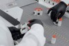 In this undated image from video provided by Regeneron Pharmaceuticals on Friday, Oct. 2, 2020, vials are inspected at the company's facilities in New York state, for efforts on an experimental coronavirus antibody drug. Antibodies are proteins the body makes when an infection occurs; they attach to a virus and help the immune system eliminate it. (Regeneron via AP)