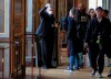 FILE - In this Thursday, March 5, 2020 file photo, an employee of the Palace of Versailles wearing a mask and gloves guides a tourist at the castel in Versailles, west of Paris. While white collar workers trying to avoid contagion can work from home or call in sick if they experience symptoms of the new virus, such precautions are not an options for the millions of waiters, delivery workers, cashiers, ride-hailing drivers, museum attendants and countless others who routinely come into contact with the public. (AP Photo/Michel Euler, File)