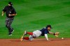 Boston Red Sox shortstop Xander Bogaerts, right, dives for a ball hit for a single by the Toronto Blue Jays' Santiago Espinal during the seventh inning of a baseball game in Buffalo, N.Y., Wednesday, Aug. 26, 2020. (AP Photo/Adrian Kraus)